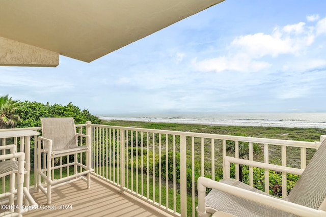 balcony featuring a view of the beach and a water view