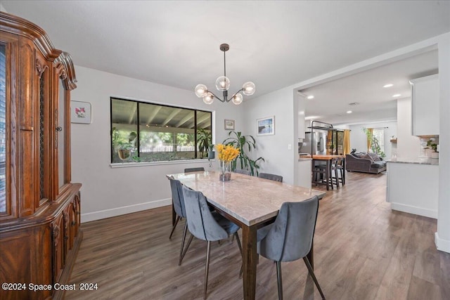 dining area with an inviting chandelier and dark hardwood / wood-style flooring