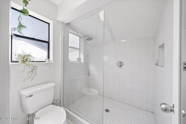 bathroom featuring toilet and a shower with shower door