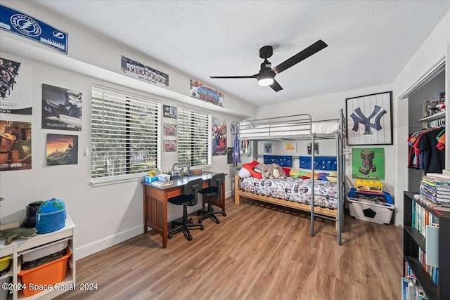 bedroom with a textured ceiling, a closet, ceiling fan, and hardwood / wood-style floors