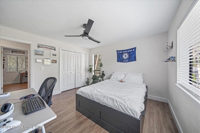 bedroom with a closet, ceiling fan, wood-type flooring, and a textured ceiling