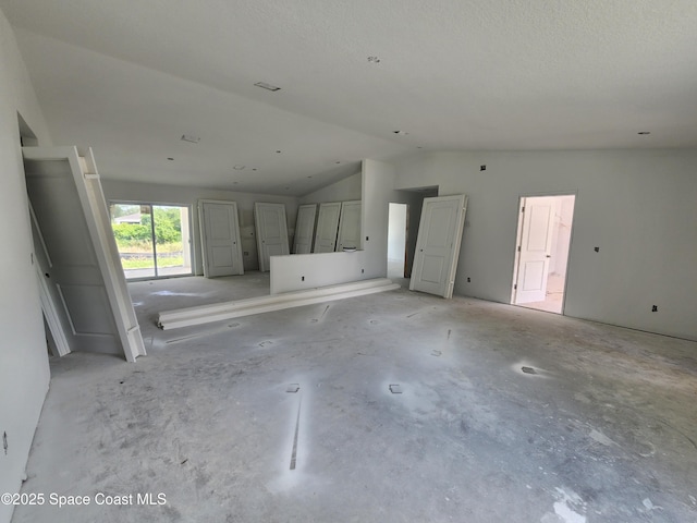 unfurnished living room with vaulted ceiling