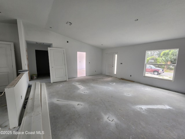 unfurnished living room featuring vaulted ceiling