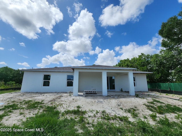 back of house featuring stucco siding, fence, and a patio