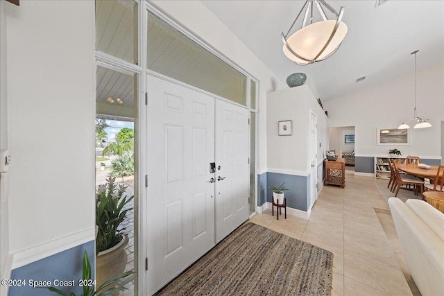 entryway featuring high vaulted ceiling and light tile patterned floors