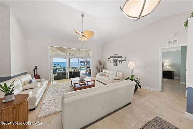 living room featuring ceiling fan, light tile patterned floors, and vaulted ceiling