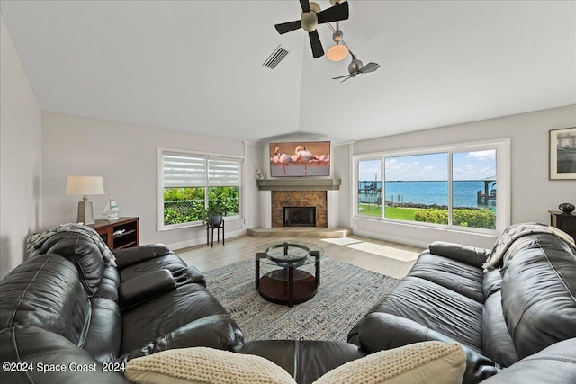 living room with light hardwood / wood-style flooring, ceiling fan, and a water view