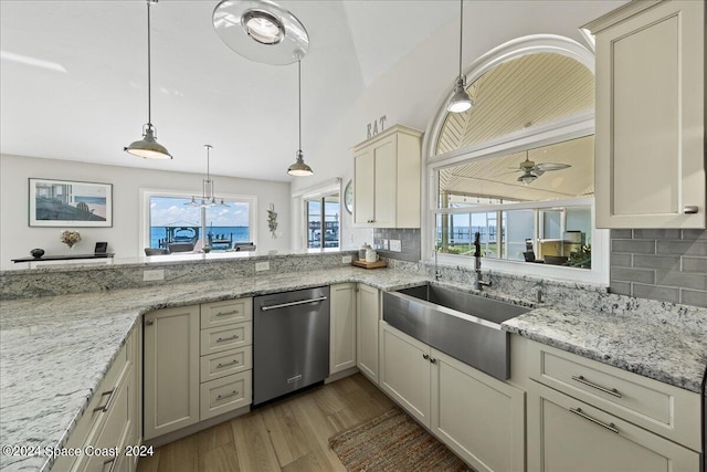 kitchen featuring tasteful backsplash, light hardwood / wood-style floors, stainless steel dishwasher, hanging light fixtures, and sink