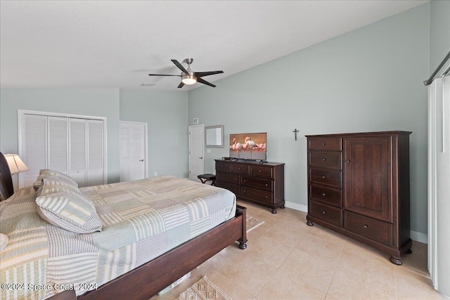 tiled bedroom with ceiling fan, a closet, and vaulted ceiling