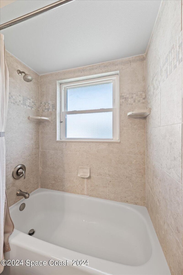 bathroom featuring tiled shower / bath