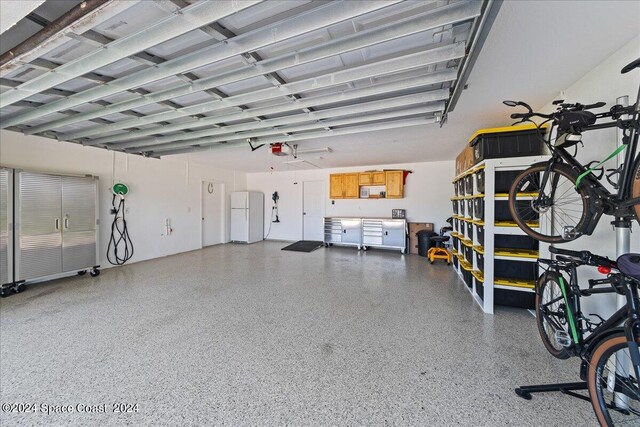 garage with a garage door opener and white fridge