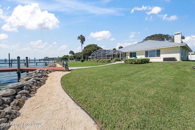 exterior space with a lanai, a boat dock, and a water view