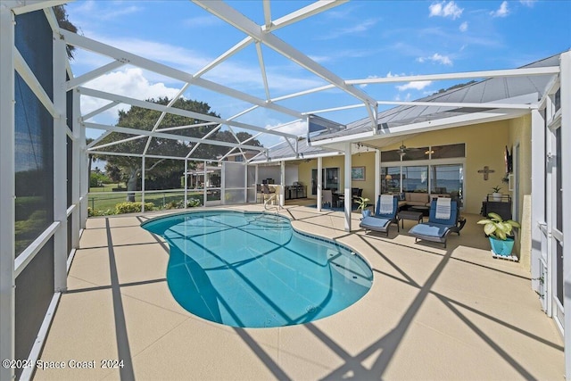 view of swimming pool with glass enclosure and a patio area