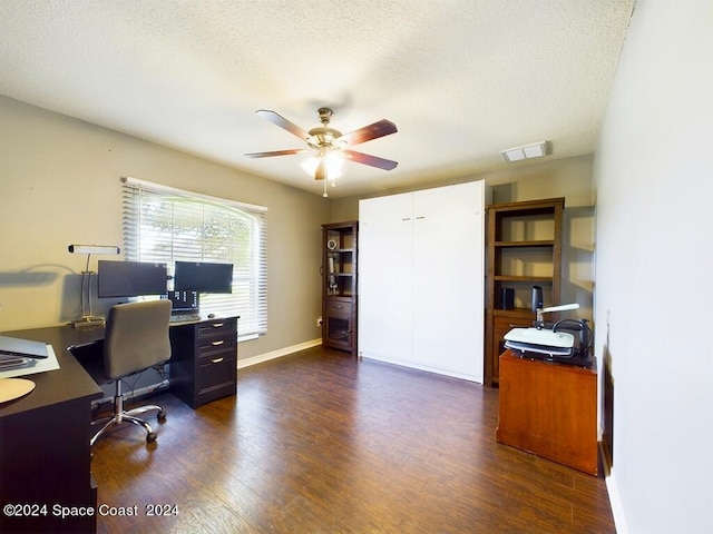 home office with a textured ceiling, dark hardwood / wood-style flooring, and ceiling fan