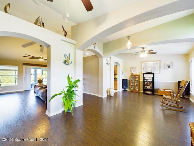 interior space with ceiling fan, lofted ceiling, and dark hardwood / wood-style flooring