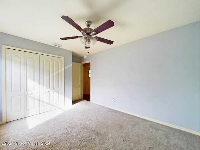 unfurnished bedroom with a closet, carpet floors, and ceiling fan