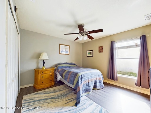 bedroom featuring ceiling fan, a closet, and dark hardwood / wood-style flooring