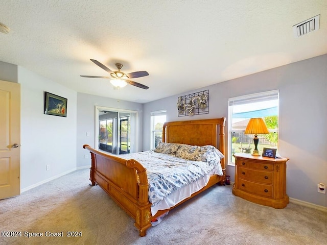 bedroom featuring multiple windows, ceiling fan, and light colored carpet