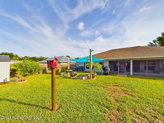 view of yard with a sunroom, a patio area, and an outdoor fire pit