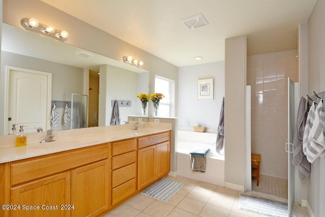 bathroom featuring shower with separate bathtub, vanity, and tile patterned floors