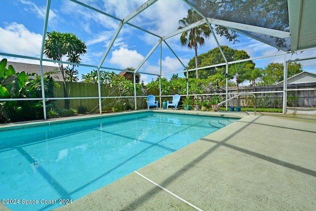 view of swimming pool with glass enclosure