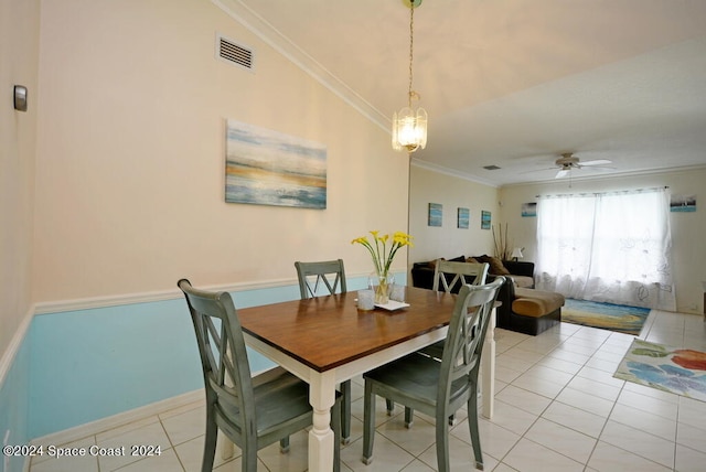 dining space featuring light tile patterned floors, ceiling fan with notable chandelier, lofted ceiling, and ornamental molding