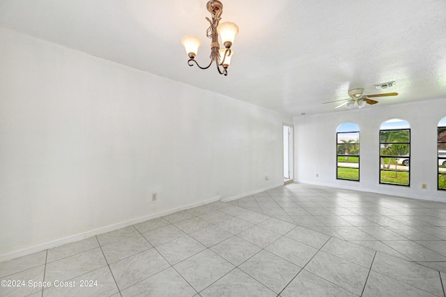unfurnished room with ceiling fan with notable chandelier, baseboards, a textured ceiling, and visible vents