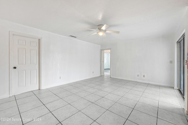 spare room featuring baseboards, visible vents, ceiling fan, and light tile patterned floors