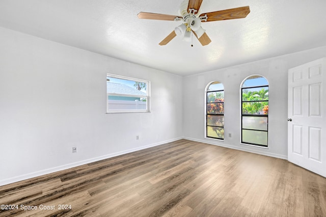 empty room featuring a textured ceiling, hardwood / wood-style floors, and ceiling fan