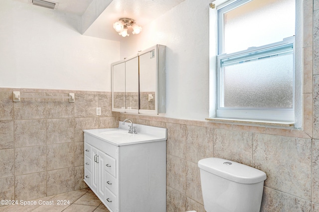 bathroom with tile walls, decorative backsplash, tile patterned floors, vanity, and toilet