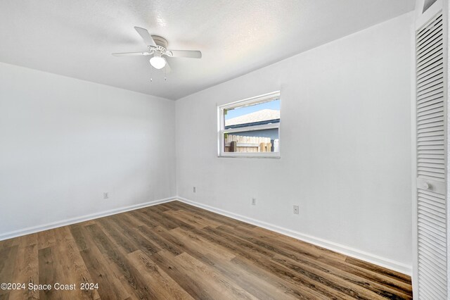 unfurnished bedroom with ceiling fan, dark wood-type flooring, and a textured ceiling