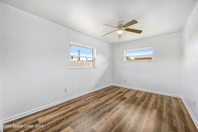 empty room with ceiling fan and dark hardwood / wood-style floors