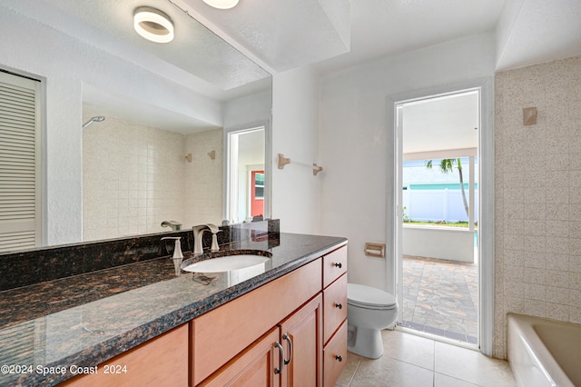 full bathroom featuring tile patterned flooring, a textured ceiling, vanity, tiled shower / bath, and toilet