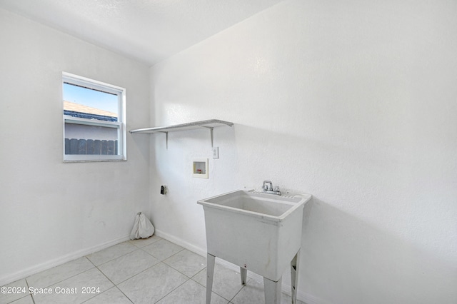 washroom with hookup for a washing machine, sink, and light tile patterned floors