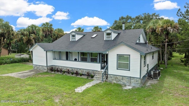 view of front of house featuring roof with shingles, central AC, and a front yard