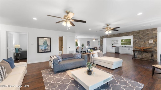 living room featuring ceiling fan, dark hardwood / wood-style floors, and sink