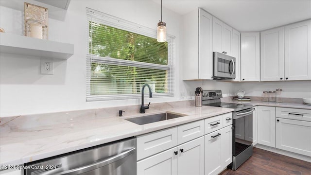 kitchen with pendant lighting, appliances with stainless steel finishes, dark wood-type flooring, sink, and white cabinets