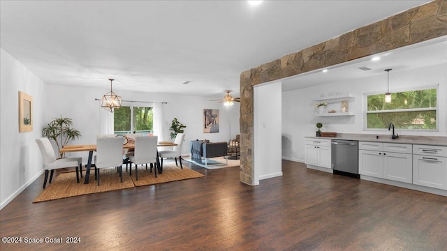 kitchen featuring dishwasher, decorative light fixtures, ceiling fan with notable chandelier, white cabinetry, and dark wood-type flooring