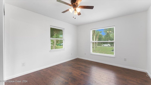 empty room with ceiling fan and dark hardwood / wood-style flooring