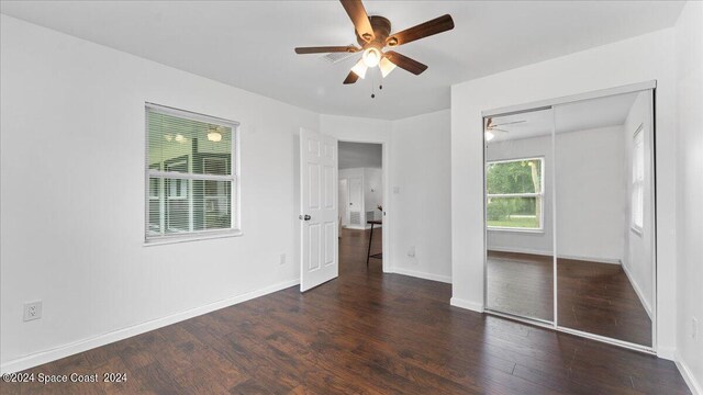 unfurnished bedroom with a closet, ceiling fan, and dark hardwood / wood-style flooring