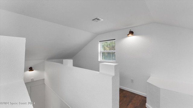 interior space featuring lofted ceiling and dark wood-type flooring