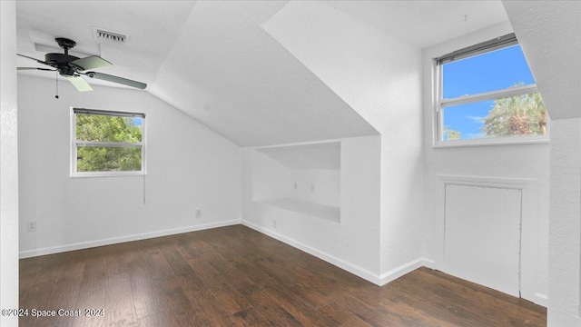 bonus room with a textured ceiling, ceiling fan, vaulted ceiling, and dark hardwood / wood-style flooring