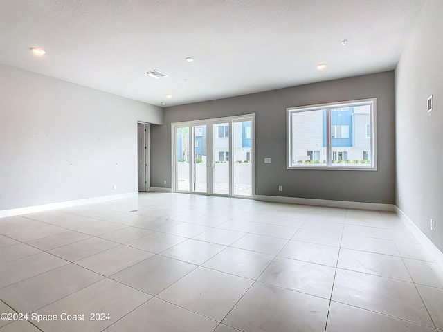 spare room with a textured ceiling and light tile patterned floors