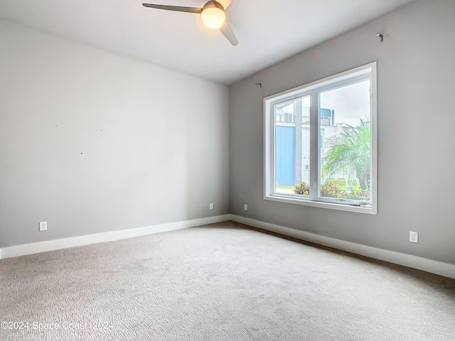 empty room featuring ceiling fan and carpet