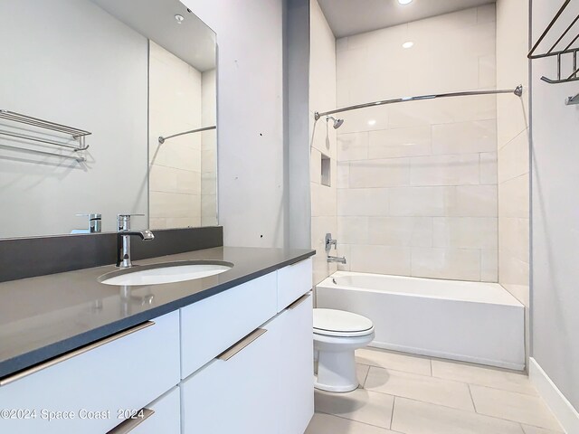 full bathroom featuring tiled shower / bath, vanity, toilet, and tile patterned floors