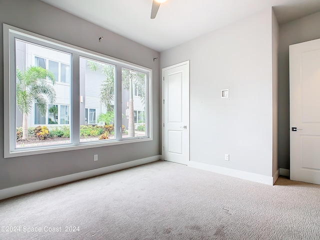 carpeted empty room featuring ceiling fan and a healthy amount of sunlight