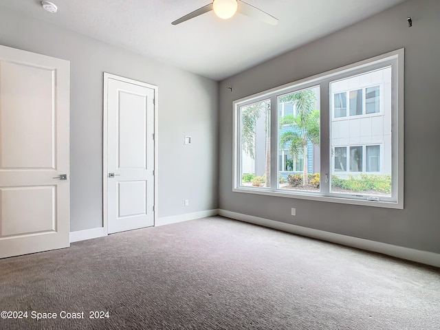 unfurnished room with ceiling fan and carpet floors