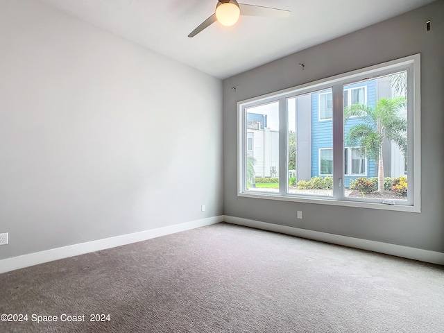 carpeted empty room featuring plenty of natural light and ceiling fan