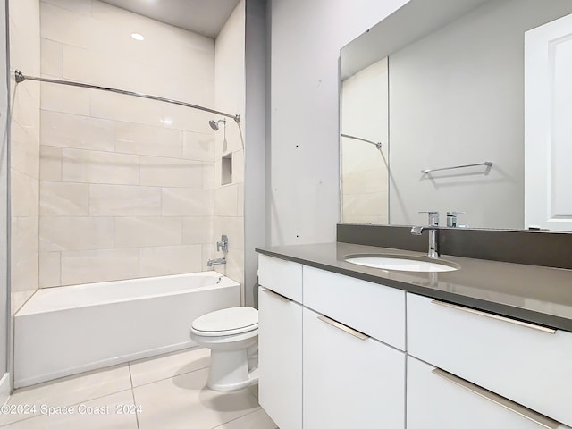 full bathroom with tiled shower / bath, vanity, toilet, and tile patterned floors