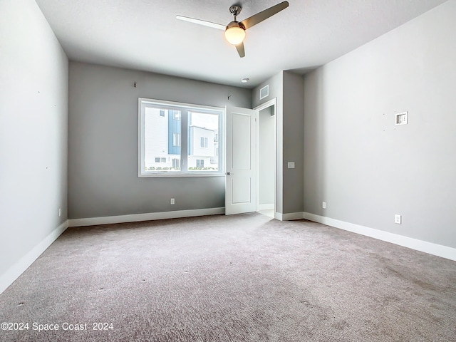 carpeted empty room featuring ceiling fan